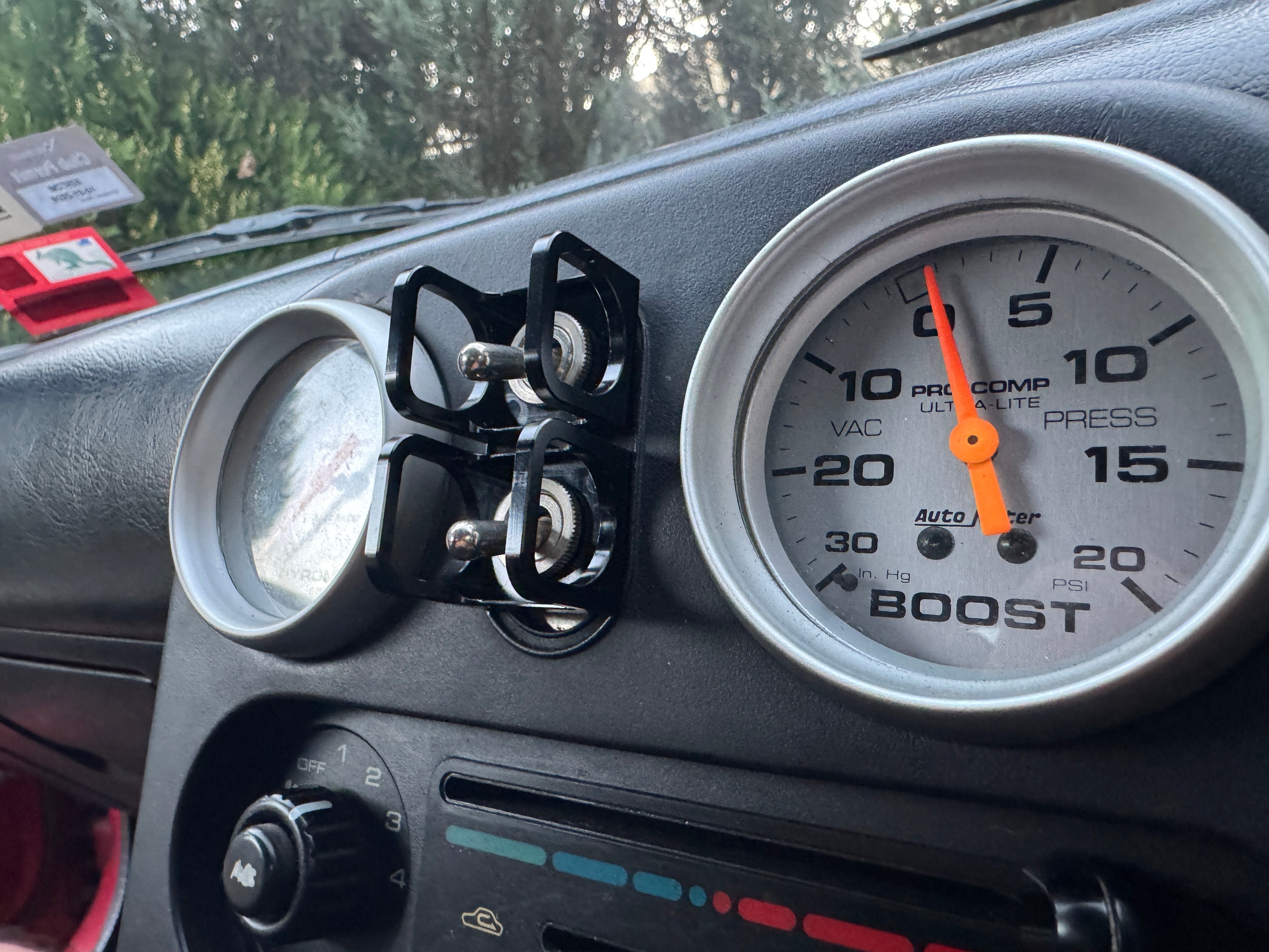 Duskie black anodized billet aluminum ISS-style toggle switch guard protecting two toggle switches on a car dashboard.