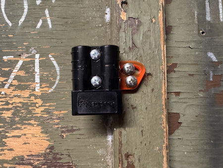 RICK 50A connector with orange acrylic bracket screwed to a weathered timber board.